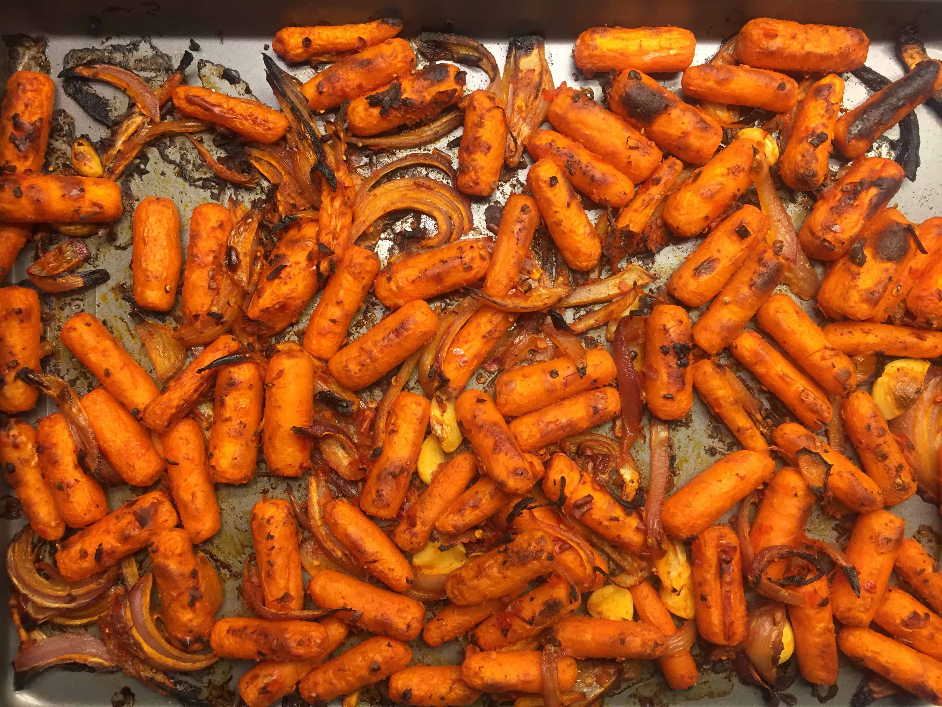 Harissa Roasted Carrot Salad starts with roasting carrots and onions