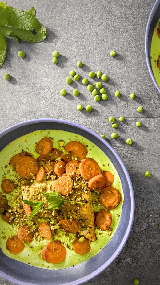 The dish shot from above, with some peas and mint strewn about on a concrete table