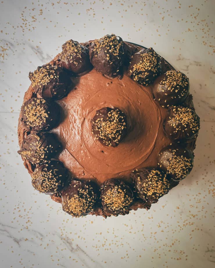 An overhead shot of my vegan flourless chocolate truffle cake with vegan chocolate buttercream and gold sanding sugar decor