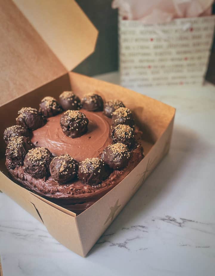 A shot of the vegan flourless chocolate truffle cake in the pastry box I decorated