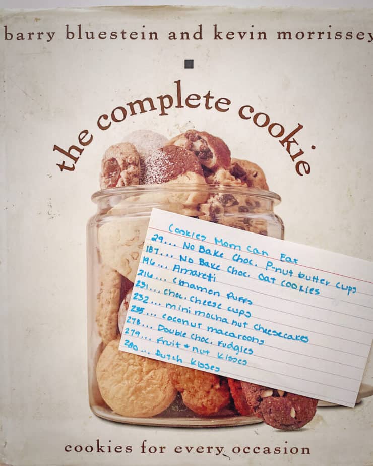A picture of my very first cookie cookbook with an index card of all of the recipes I found that my Mom could eat after she was diagnosed with wheat and corn allergies