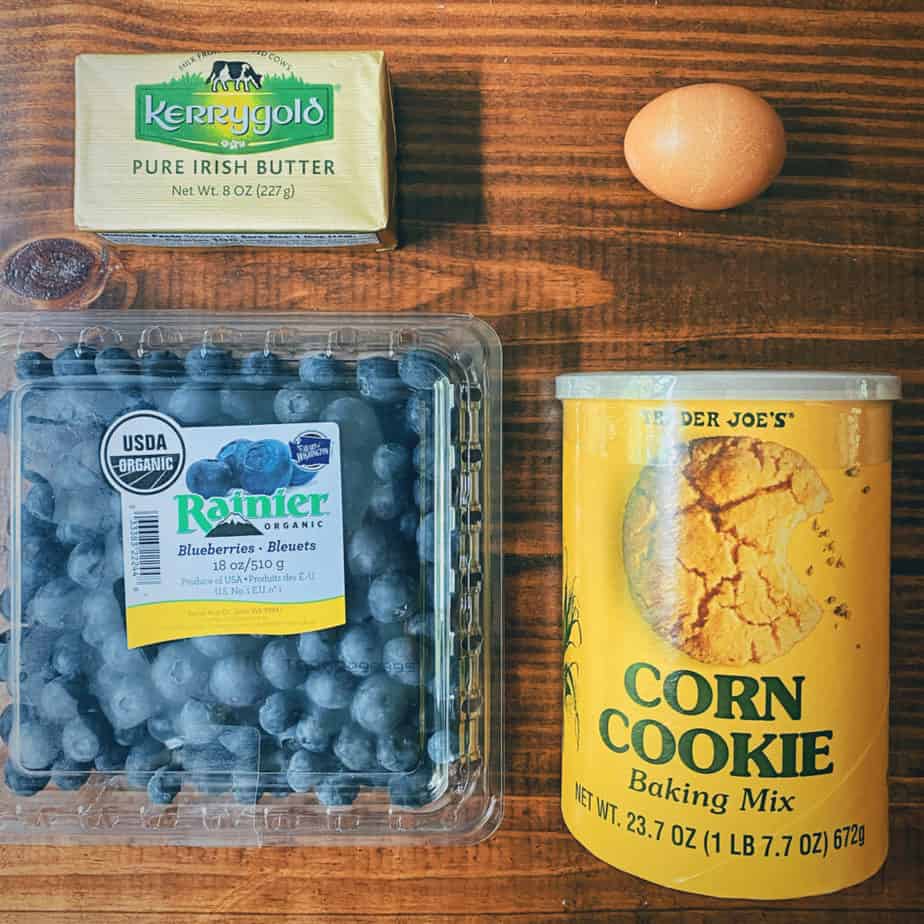 A picture of all the ingredients you need for blueberry corn cookies: a stick of kerrygold salted butter, one organic, free range egg, some organic blueberries and trader joe's corn cookie mix.