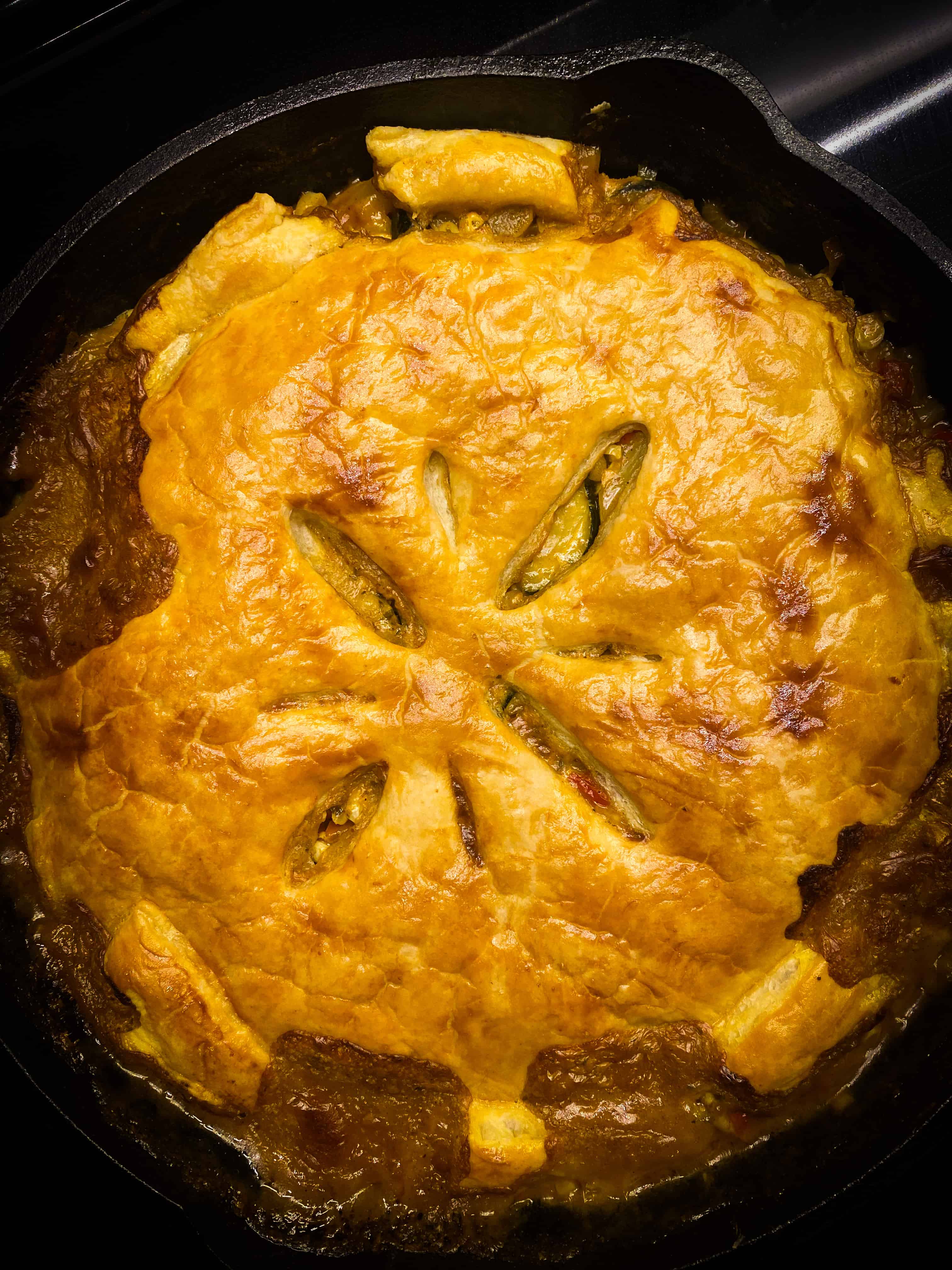 Look how pretty that egg washed pie crust looks, all bubbling over with cheesy, vegetable-y goodness! It's golden brown and perfect in the cast iron pan.