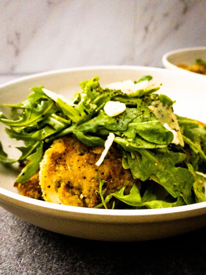 Close up shot of chicken paillards topped with arugula salad