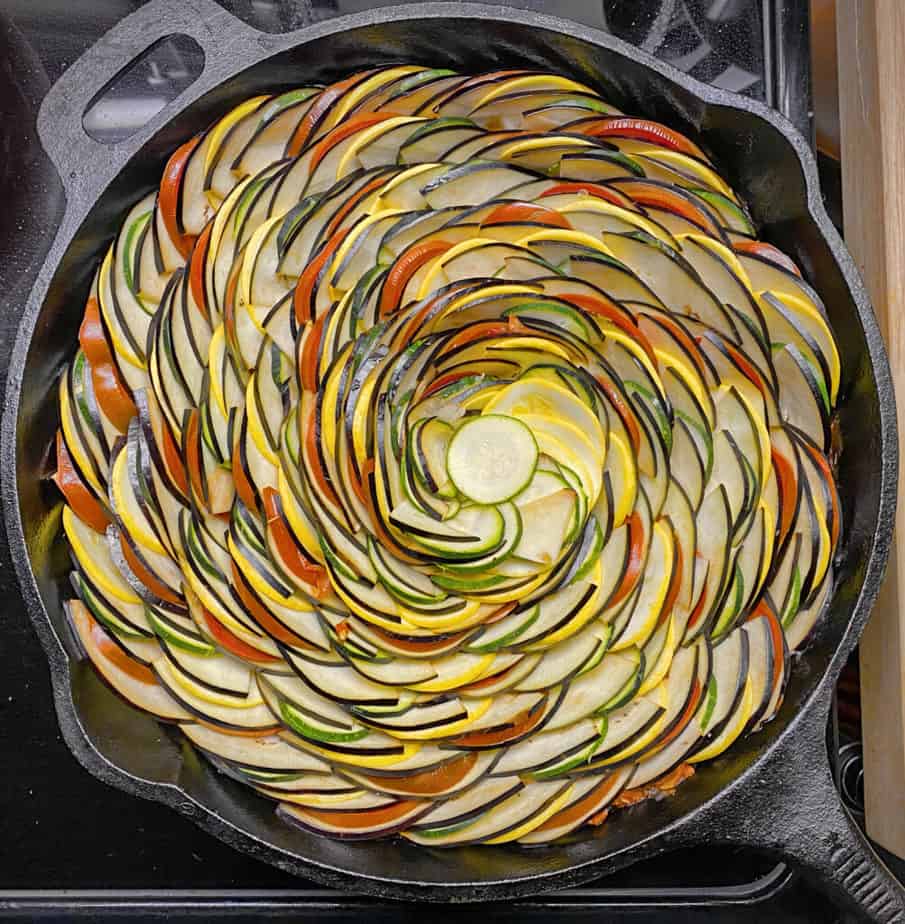 Completed spiral of ratatouille veggies in a cast iron skillet