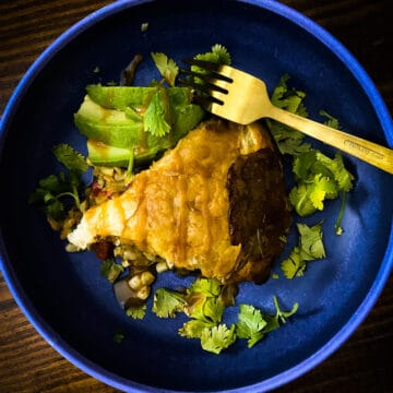 overhead shot of vegetarian calabacitas pot pie slice in a blue plate.