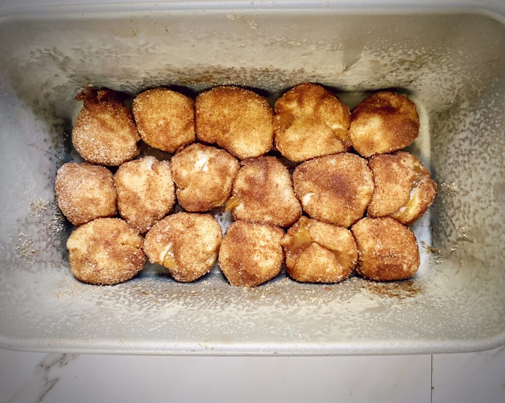 first layer of cinnamon sugar dipped dough balls for cinnamon apple monkey bread