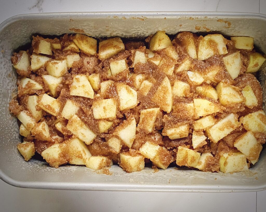 final layer of apple cinnamon monkey bread in the tin - cinnamon apple sugar mix