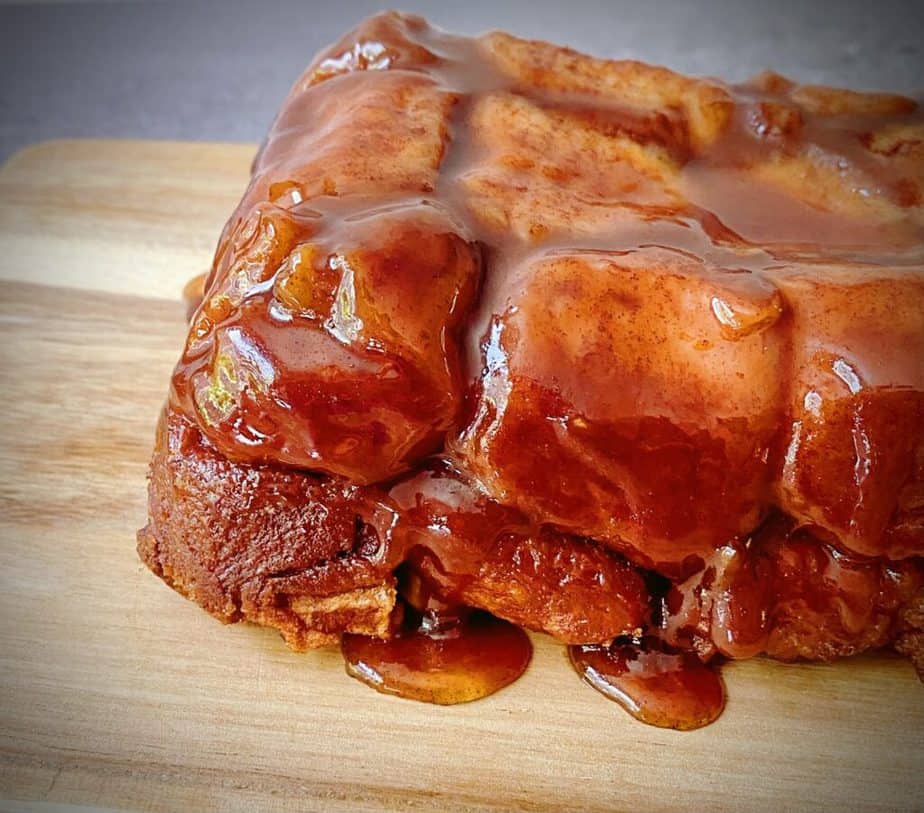 close up sideways shot of completed apple cinnamon monkey bread on a wooden cutting board