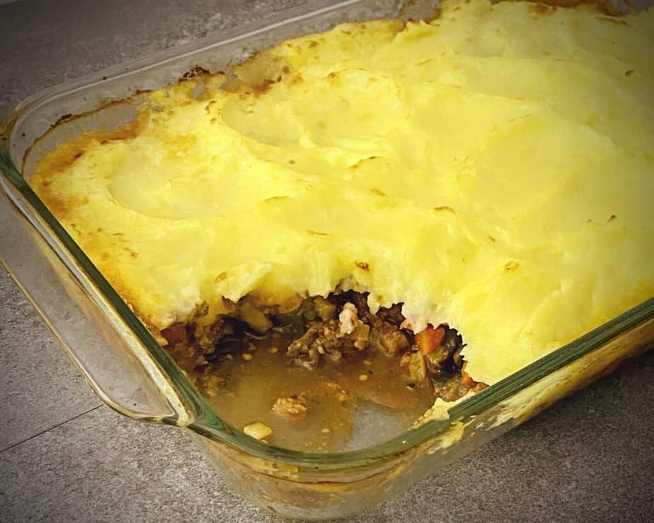 finished moussaka style shepherd's pie in a pyrex 9 x 13 with a scoop out of it