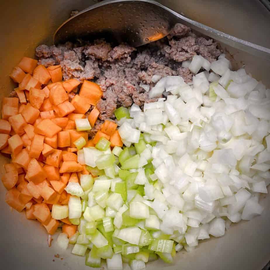 cooked lamb, raw diced carrots, celery and onions in a dutch oven
