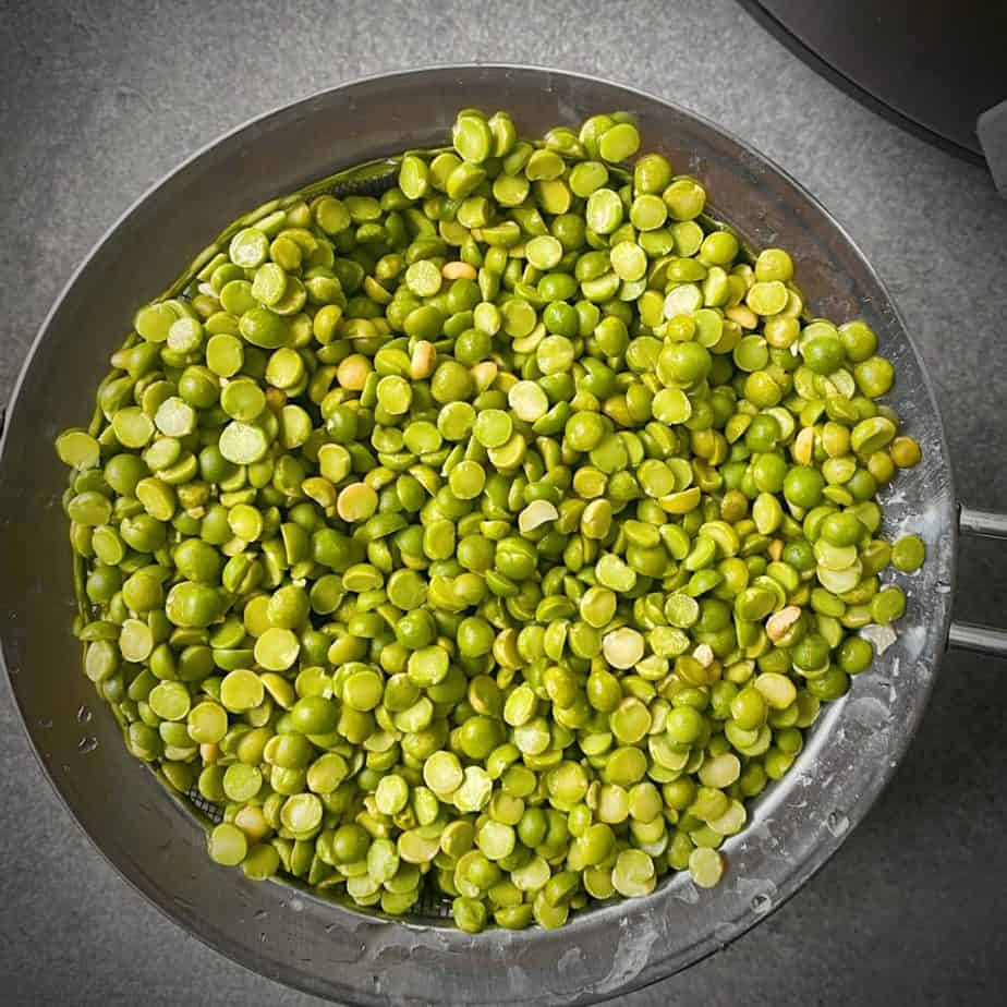 dried split peas in a strainer after being picked through and rinsed