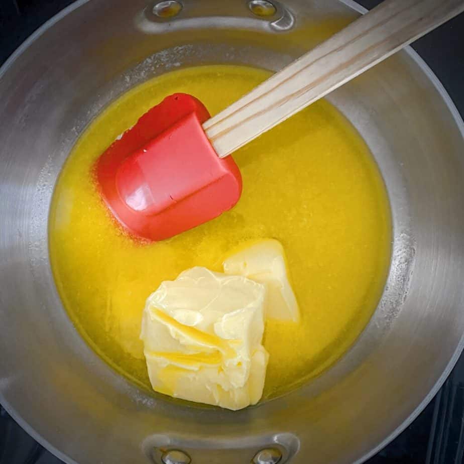 butter melting in a saucepan with a red silicone spatula