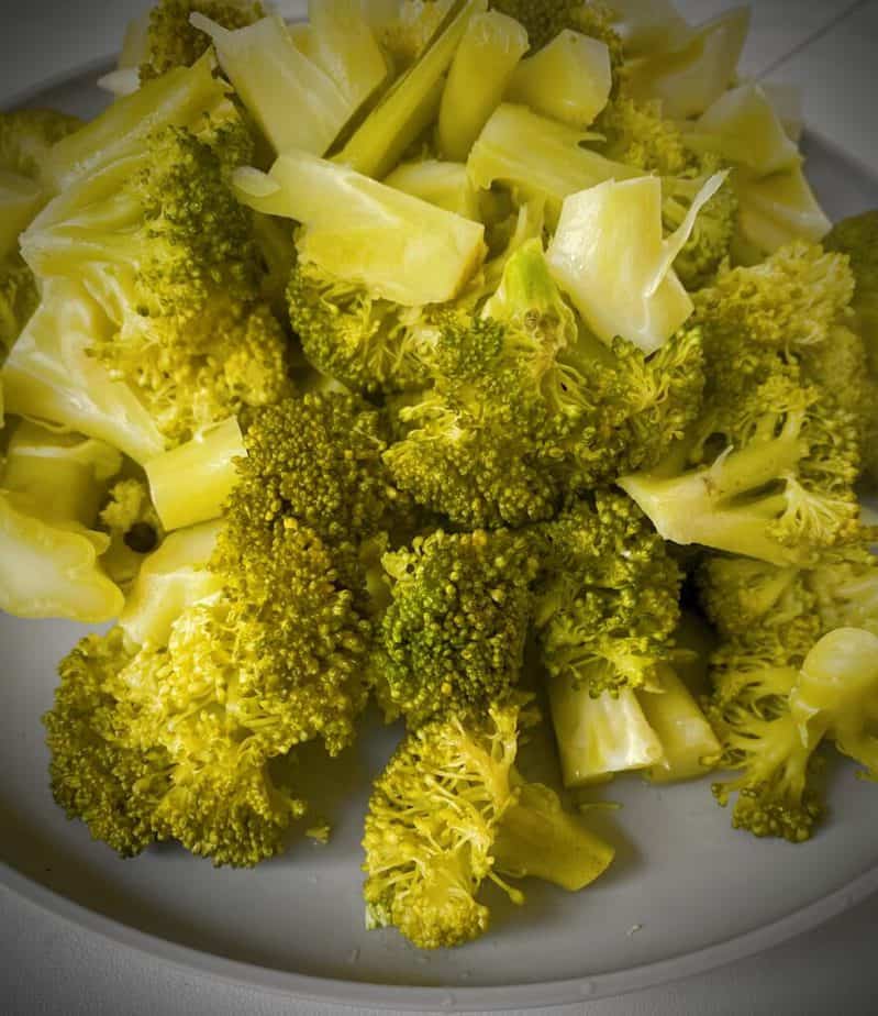 cooked broccoli florets on a light grey plate
