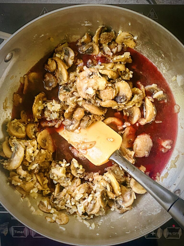 mushroom gravy after wine has just been added to the sauté pan and is still clearn