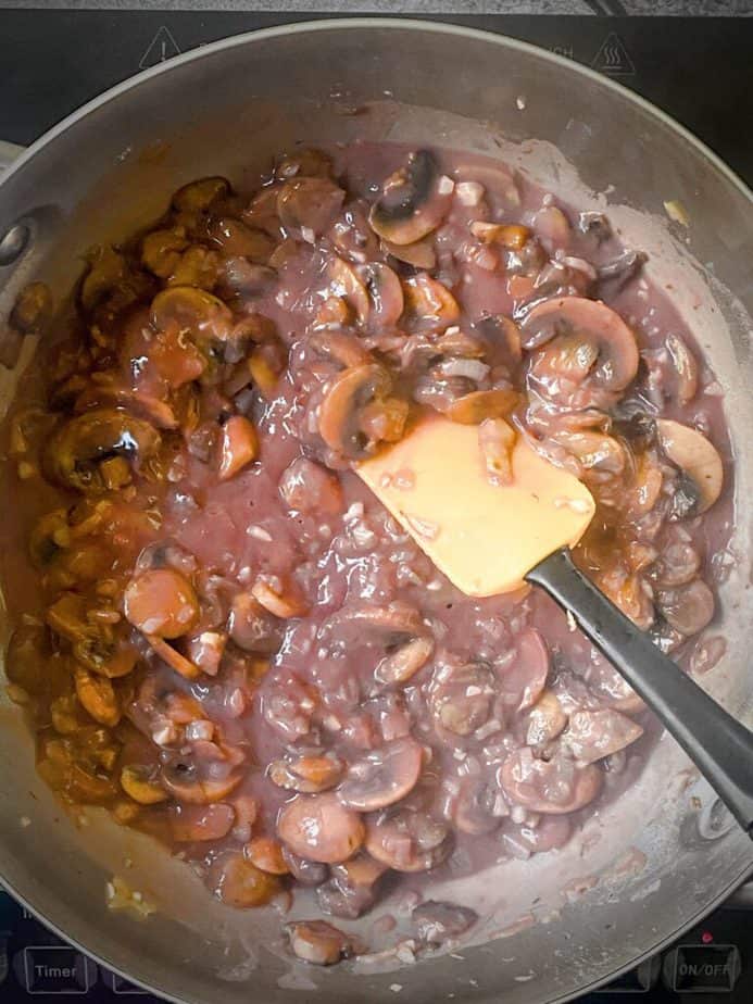 mushroom gravy after wine has reduced and mixed with flour to make a thick, opaque sauce