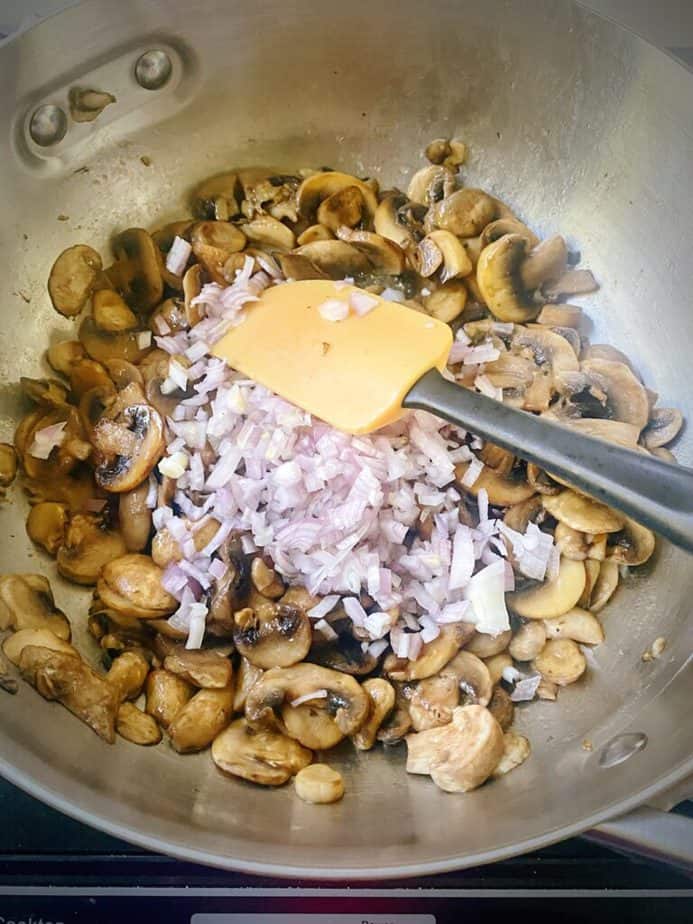 raw onions added to the sauté pan with browned mushrooms