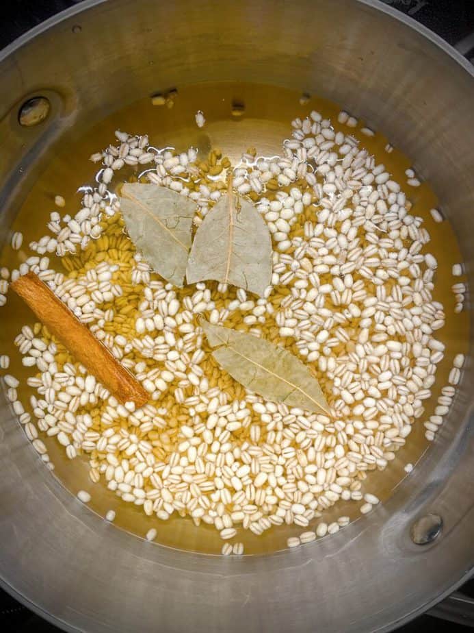 barley, apple cider, water, bay leaves and a cinnamon stick in a saucepan prior to boiling