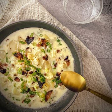 flat lay square hero of a bowl of instant pot loaded baked potato soup.