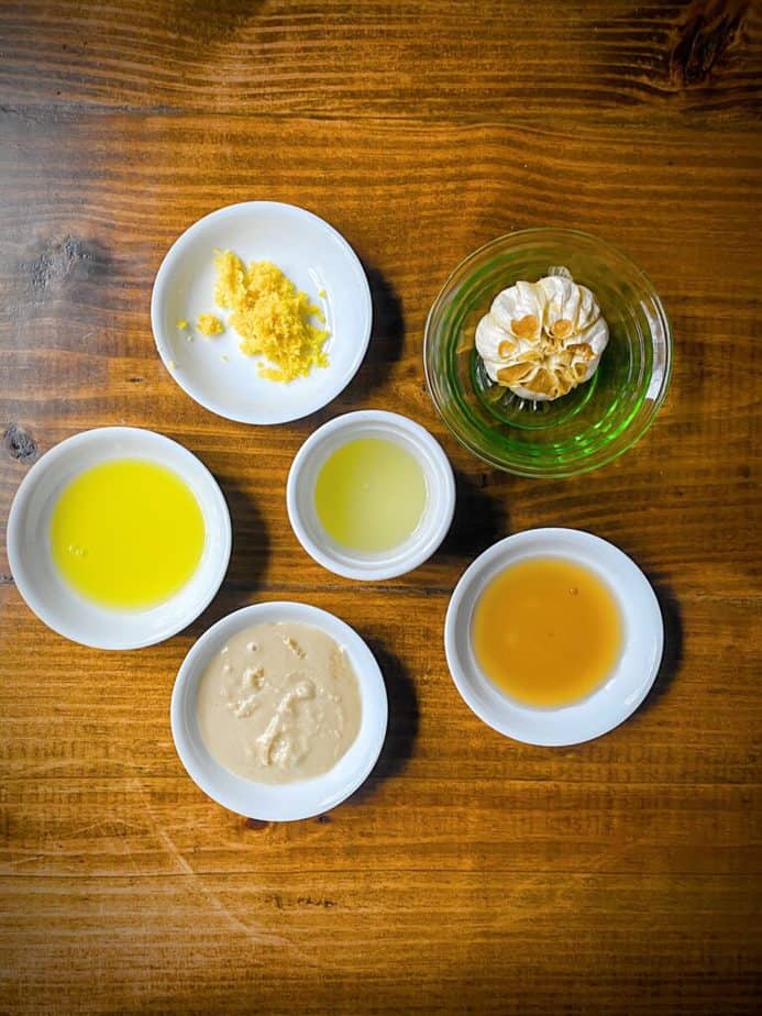 lemon zest, lemon juice, head of roasted garlic, maple syrup, tahini and olive oil as mis en place for roasted garlic tahini dressing