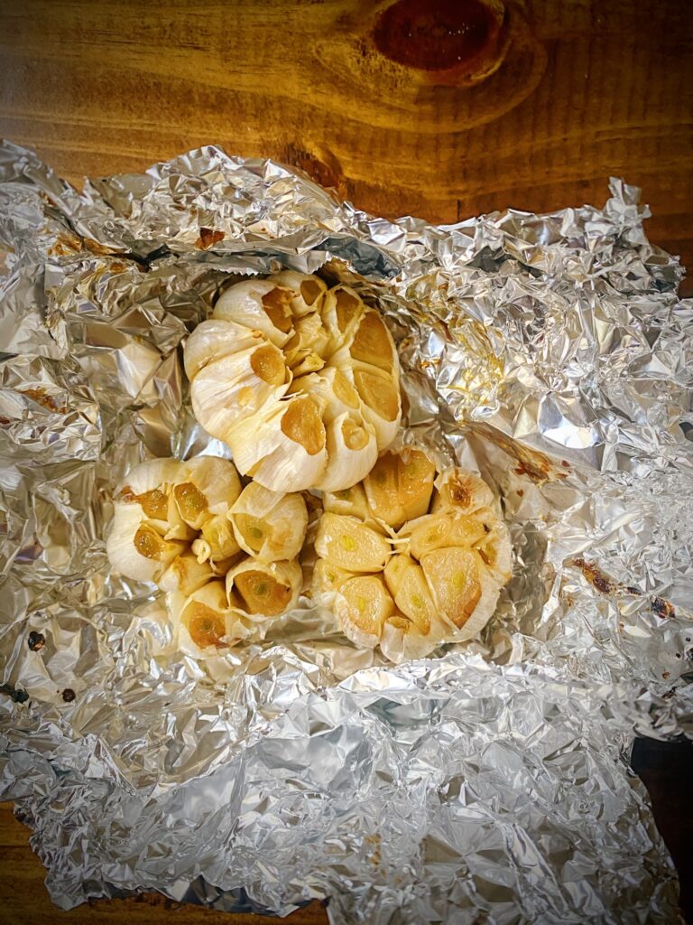 three heads of roasted garlic in tinfoil
