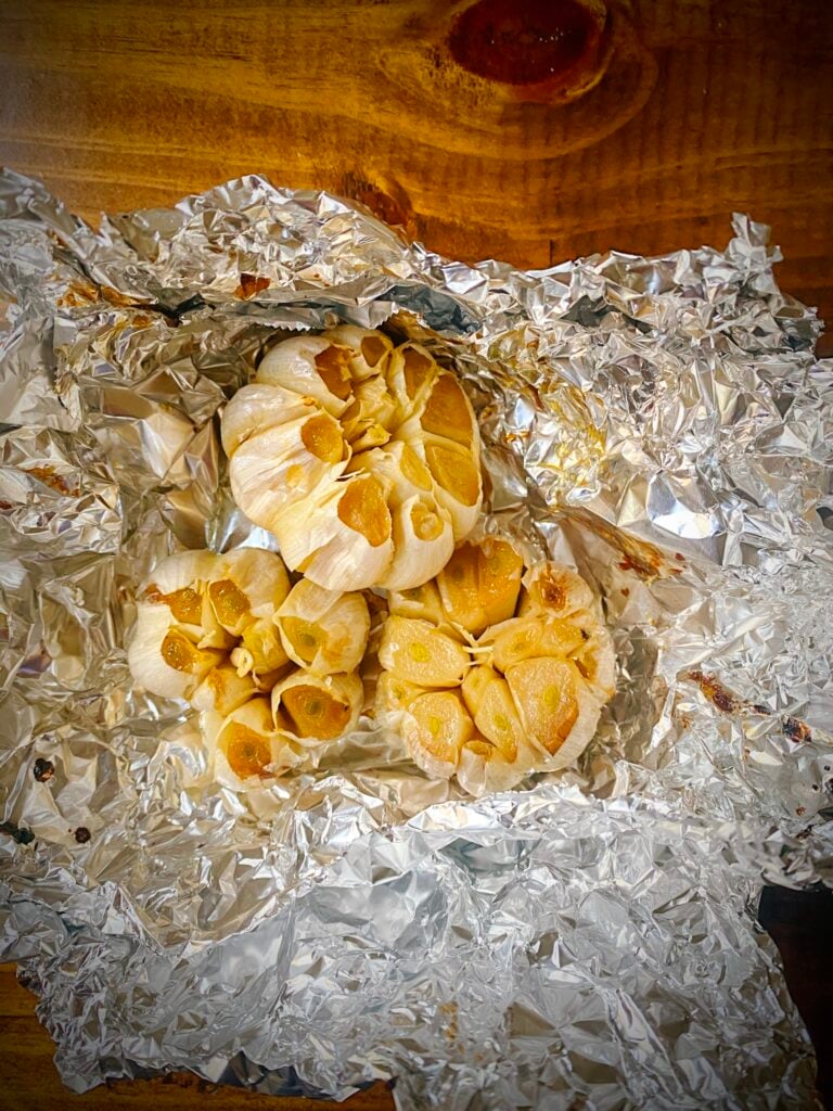 three heads of roasted garlic in tinfoil