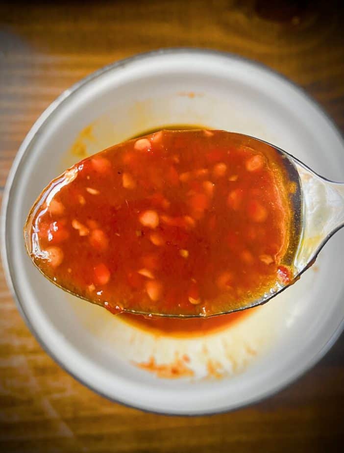 close up spoonful of harissa maple sauce mix