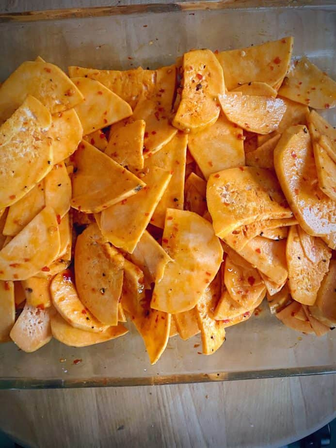 sweet potato slices after being tossed with sauce and seasoning