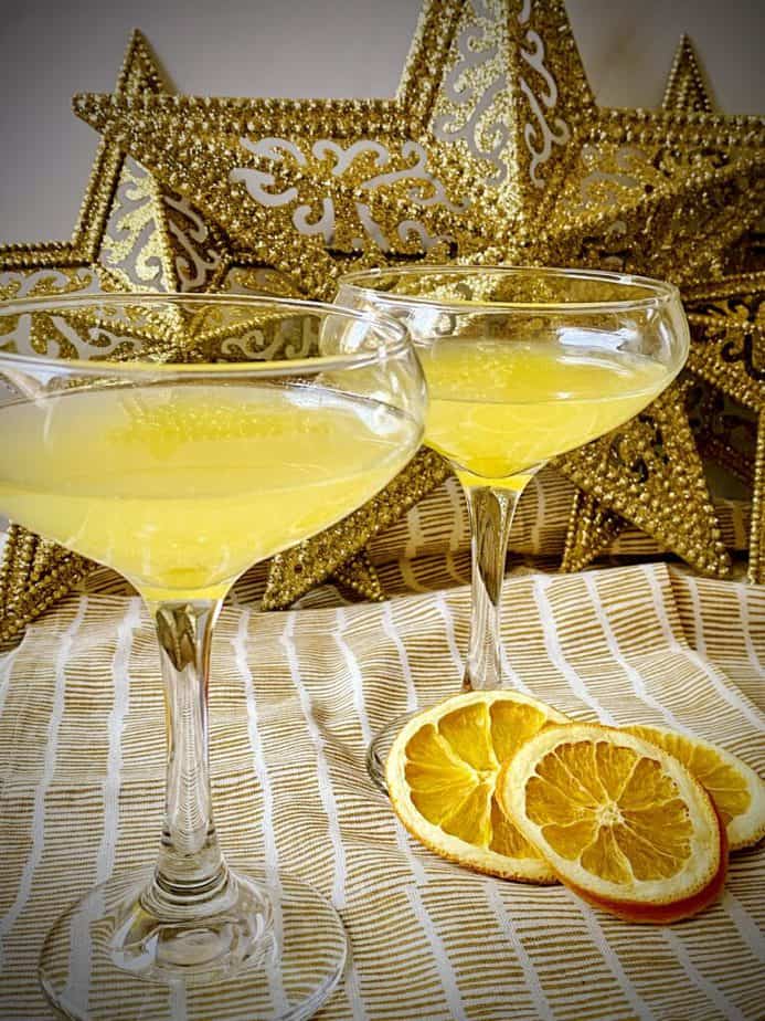 close up shot of the abbey cocktail in two coupe glasses with dried orange slices