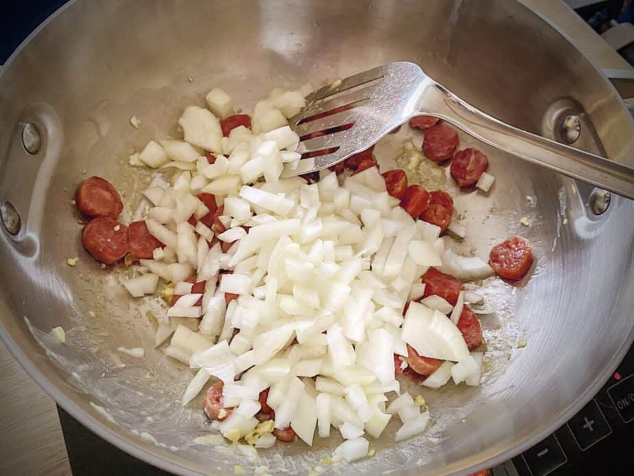 onions just added to the pan with the Chinese sausage