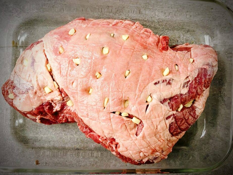 leg of lamb roast that has been trimmed and had pieces of garlic pushed into small cuts all over