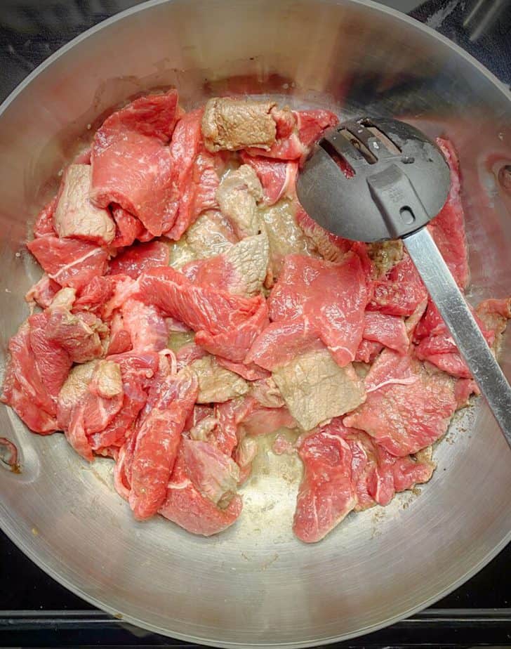 thinly sliced beef being cooked