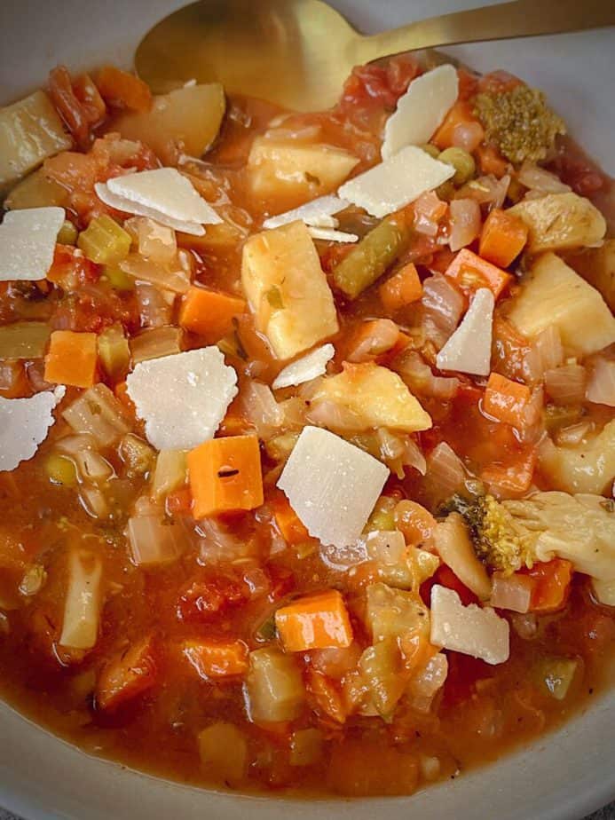 very close up shot of plated easy instant pot vegetable soup garnished with parmesan shavings