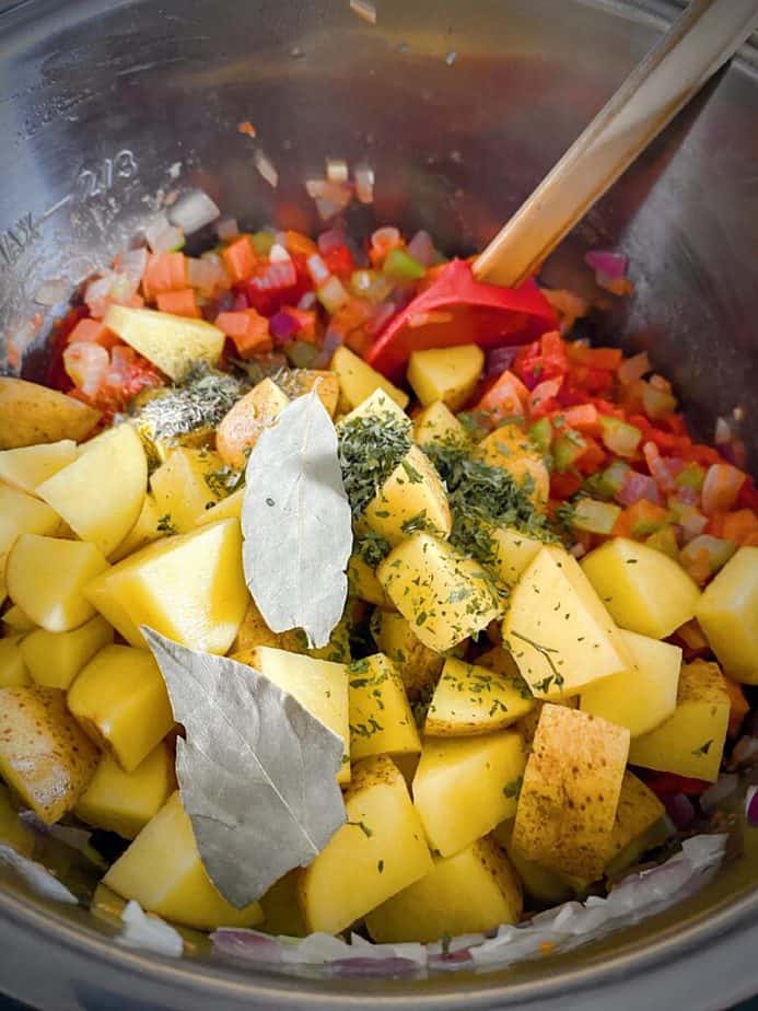 diced potatoes and herbs added to metal insert of instant pot