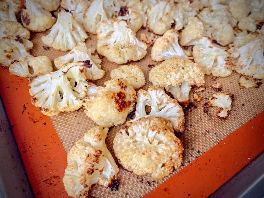 close-up shot of roasted cauliflower florets after second roast. The edges are caramelized and golden brown. 