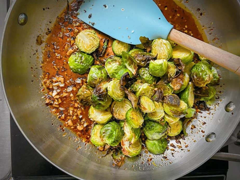 air fried brussels sprouts added to pan with kung pao sauce