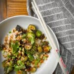 kung pao brussels sprouts in white pasta bowl over jasmine rice