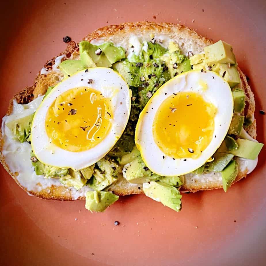 close up overhead shot of halved seven minute turmeric pickled egg on avocado toast