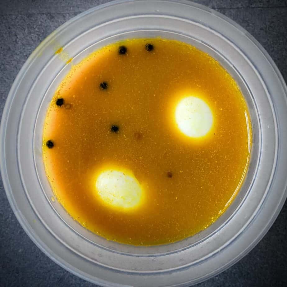 overhead shot of peeled eggs soaking in pickling brine
