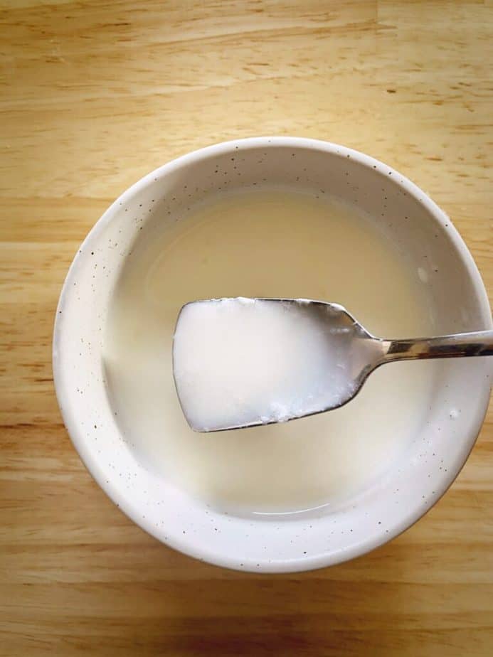spoon showing consistency of homemade buttermilk