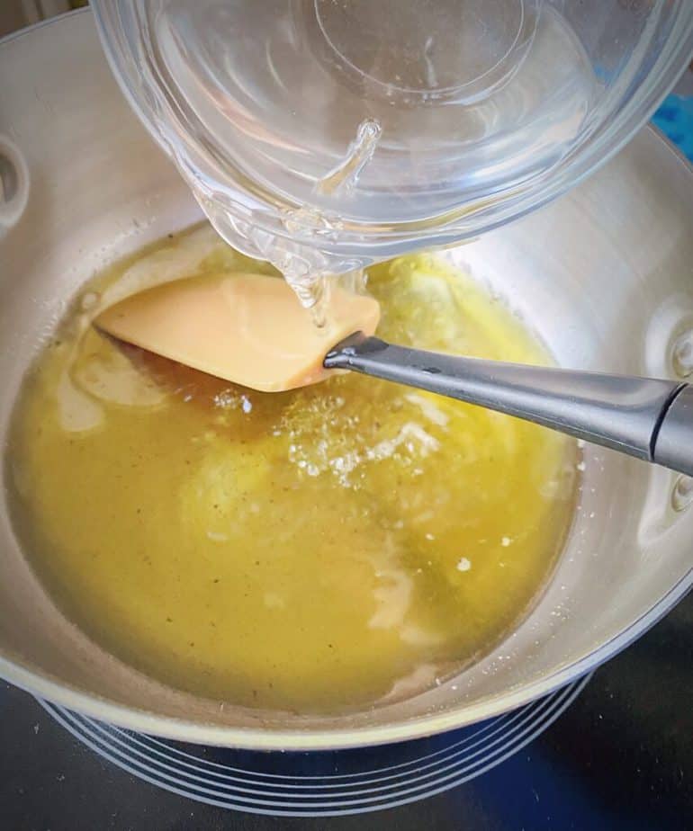 water being poured into saucepan with cannabutter