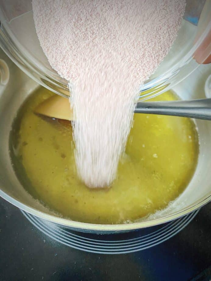 flavored gelatin being poured into saucepan with water and cannabutter