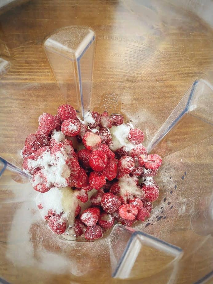 raspberries, amaretto and sugar in the pitcher of a blender