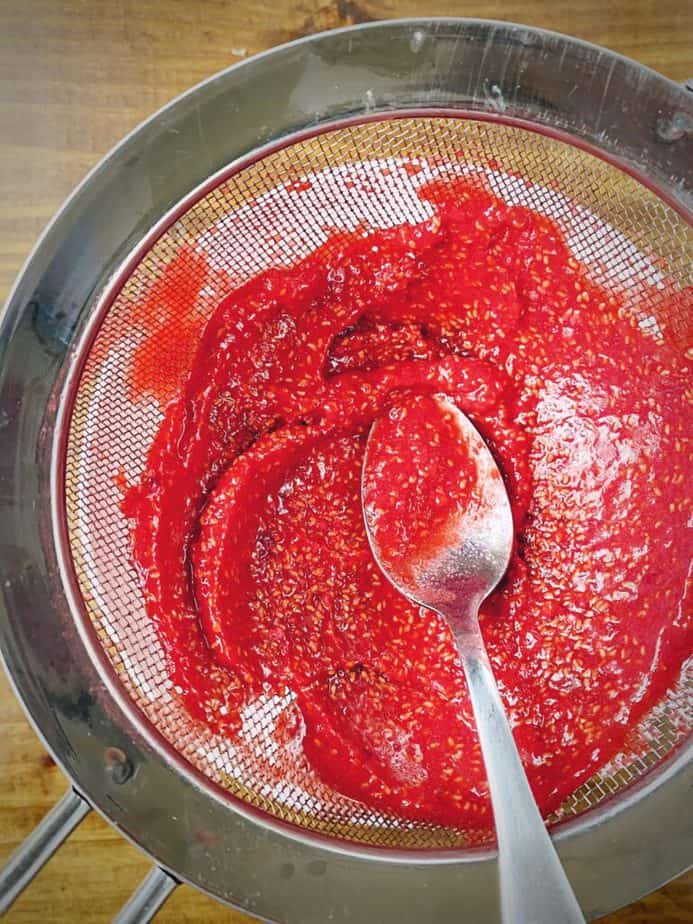 overhead shot illustrating large number of seeds that the sieve caught when straining the raspberry sauce