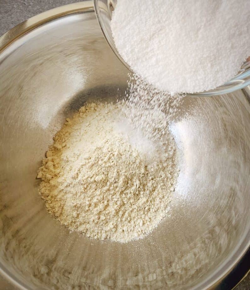sugar being poured into a mixing bowl with kodiak pancake mix
