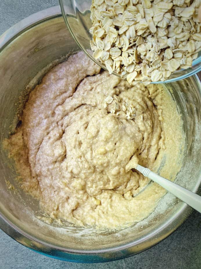 adding rolled oats to the whole wheat banana muffin batter