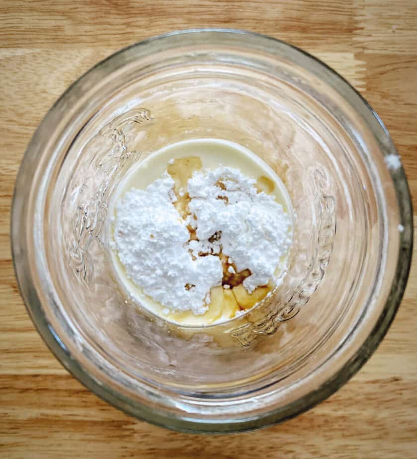 overhead shot of mason jar with cream, powdered sugar and vanilla