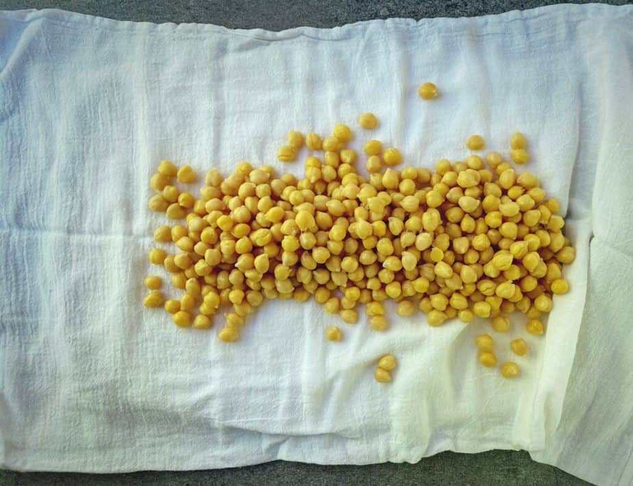two cans of chickpeas poured out onto a kitchen towel