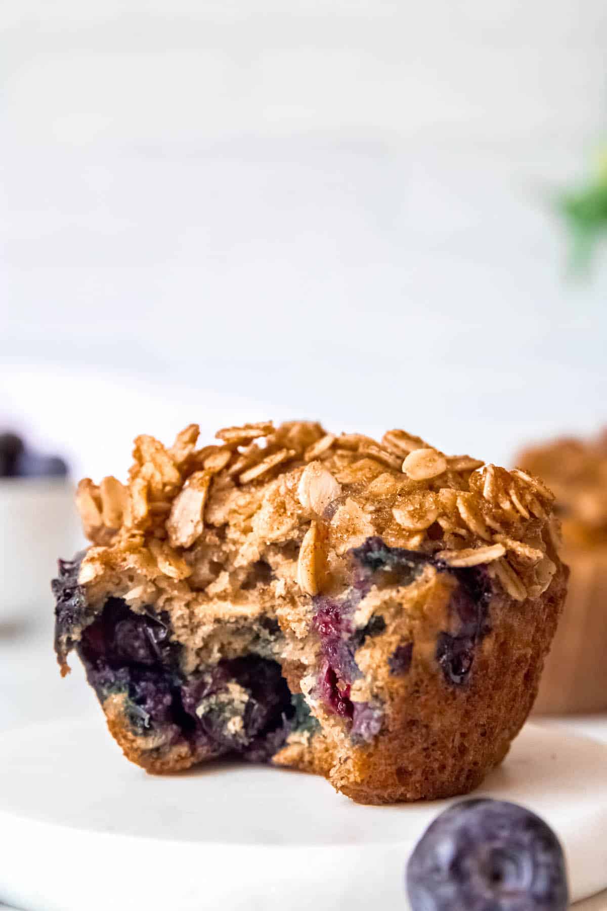 closeup shot of a banana blueberry oatmeal muffin with a bite taken out.