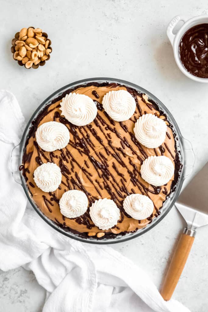 rosettes of whipped cream placed around the edges of the chocolate peanut butter pie.